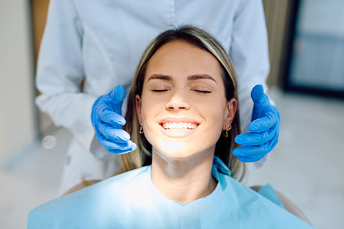 A dentist assessing a woman after clear aligner treatment